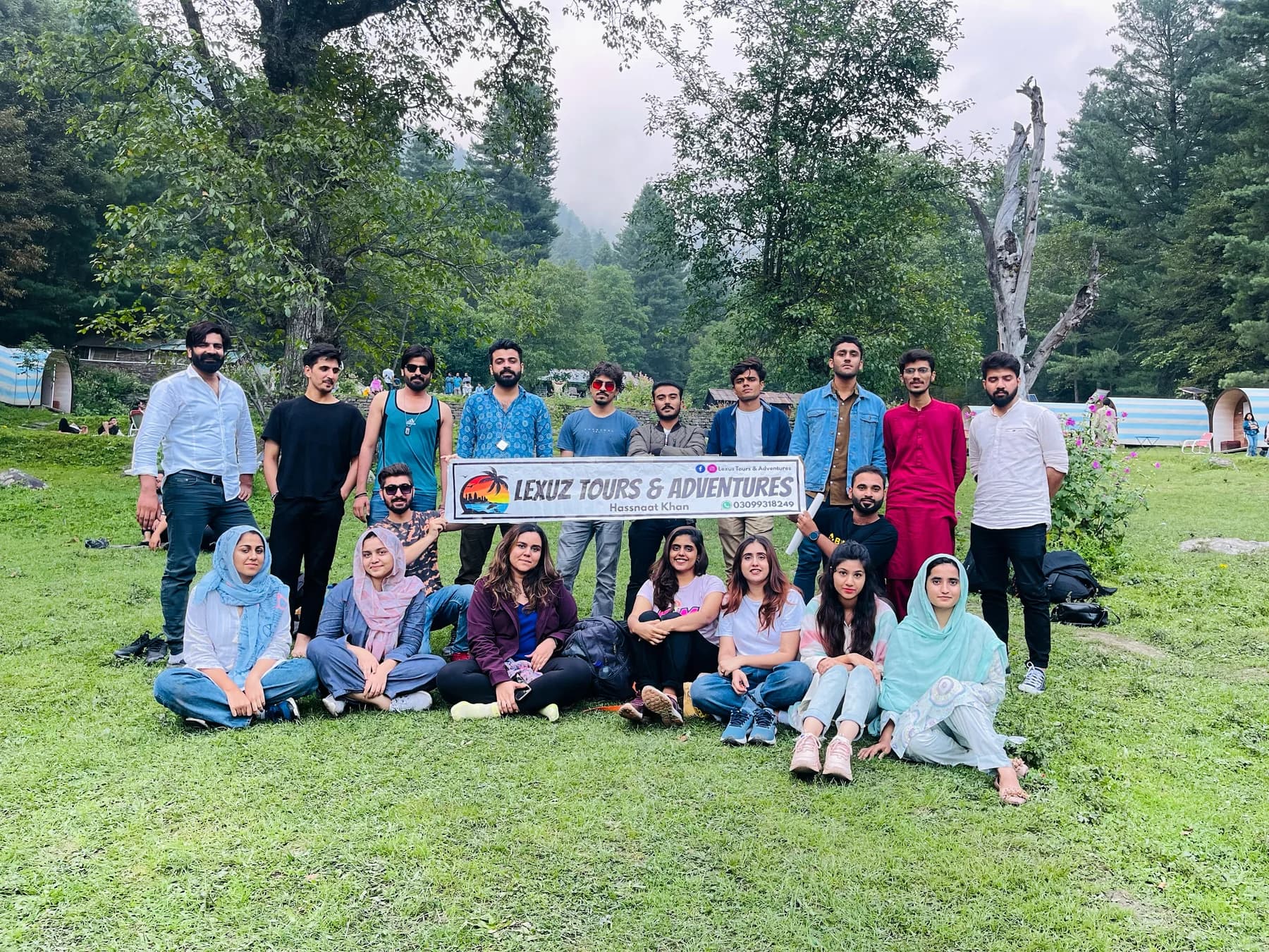 Lexuz Tours group with a banner in a forest clearing