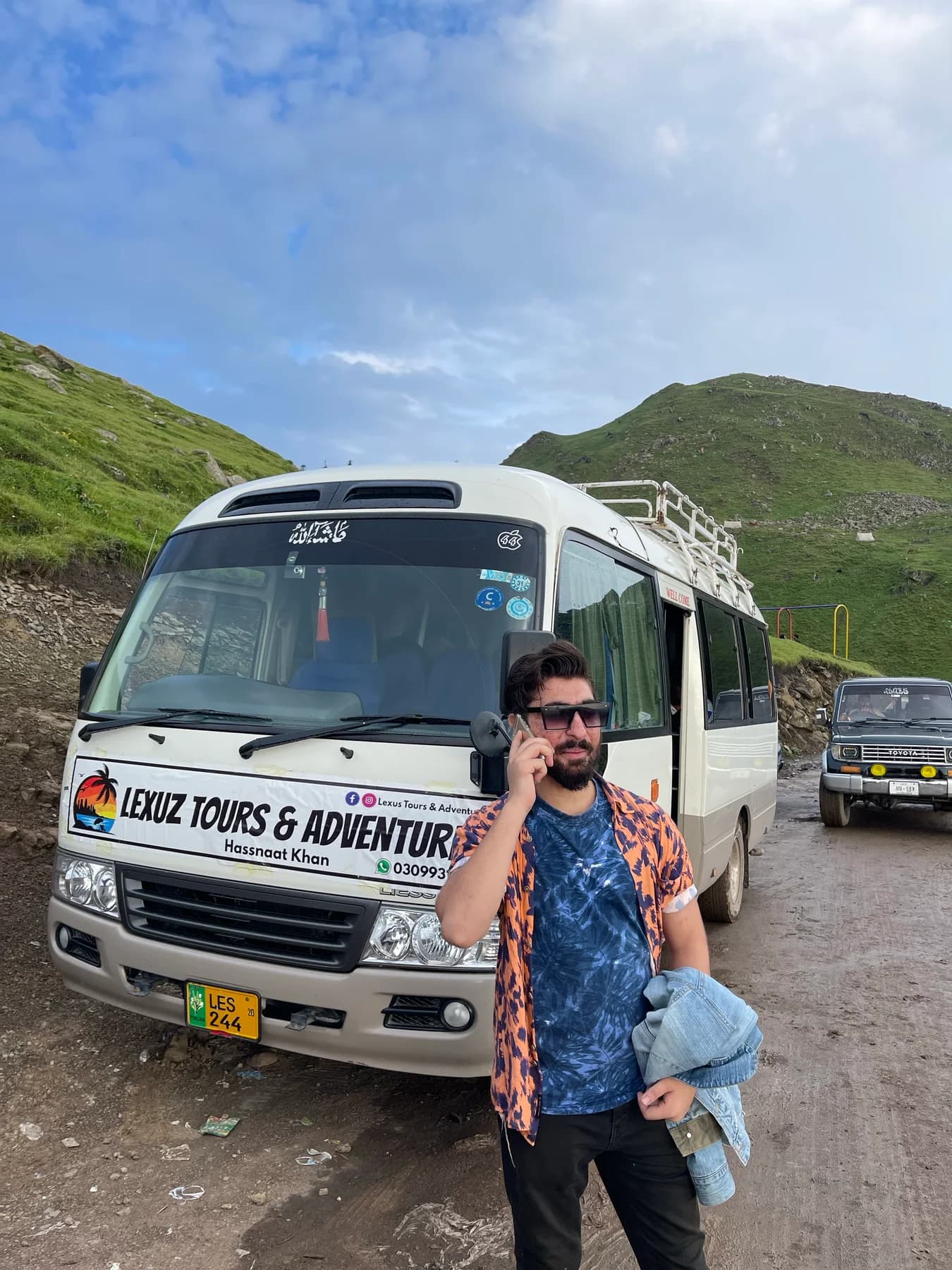 Traveller beside a Lexuz coach with mountain scenery