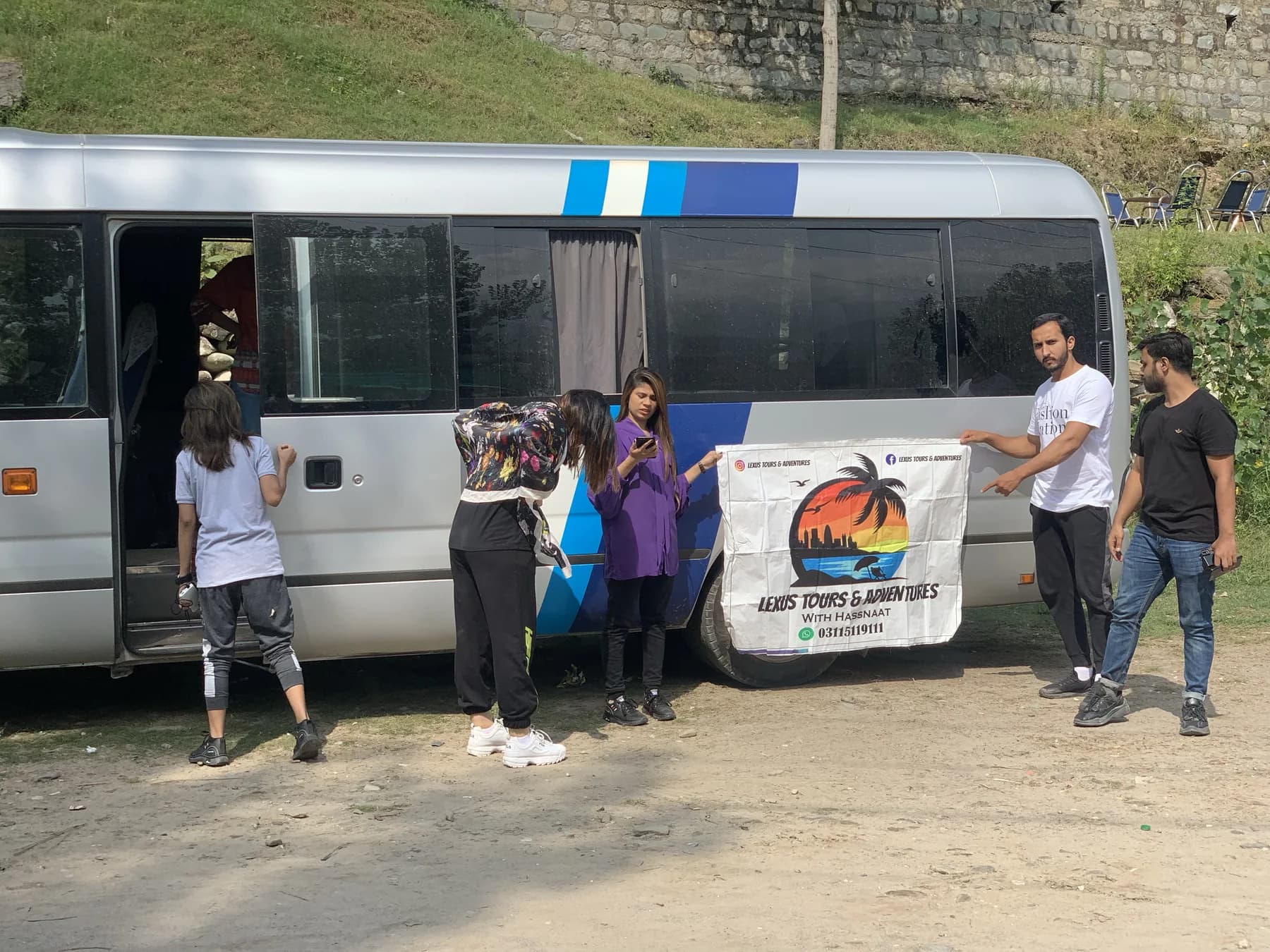 Travellers preparing to board a Lexuz Tours coaster